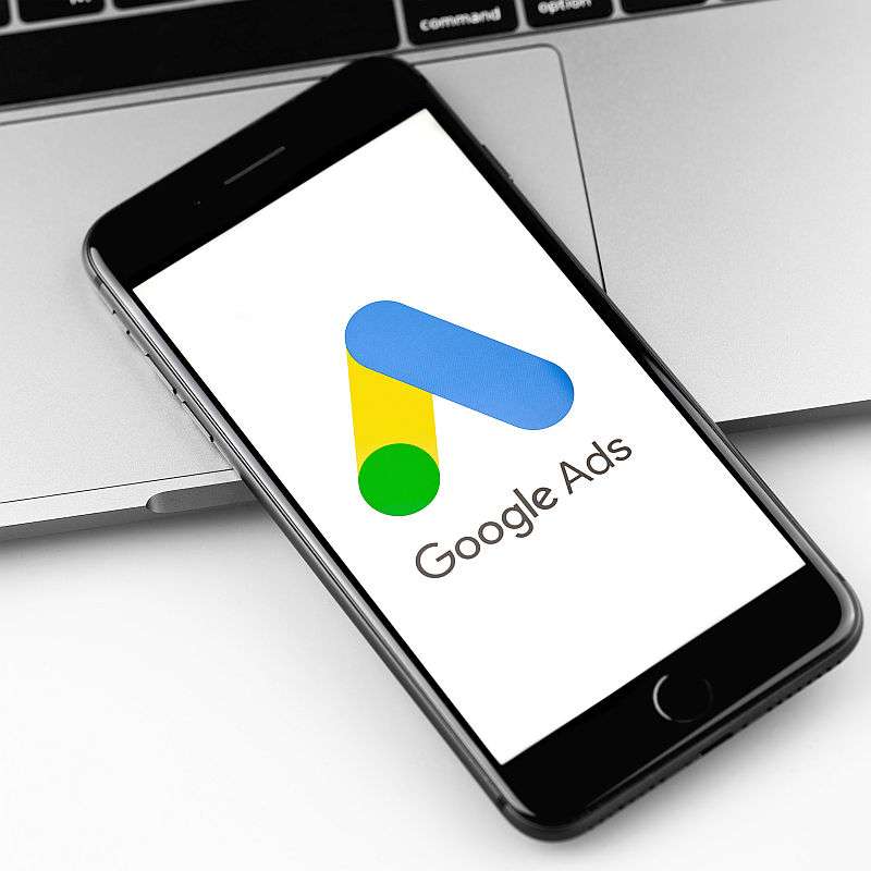 Google Ads (AdWords) start page on the screen iPhone, notebook closeup background. Ads is a service of contextual, basically, search advertising from Google. Moscow, Russia - December 19, 2019